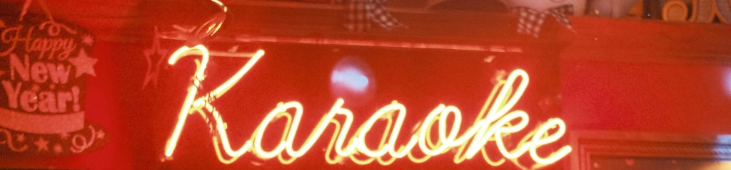 Neon sign lit up with the word 'karaoke'.